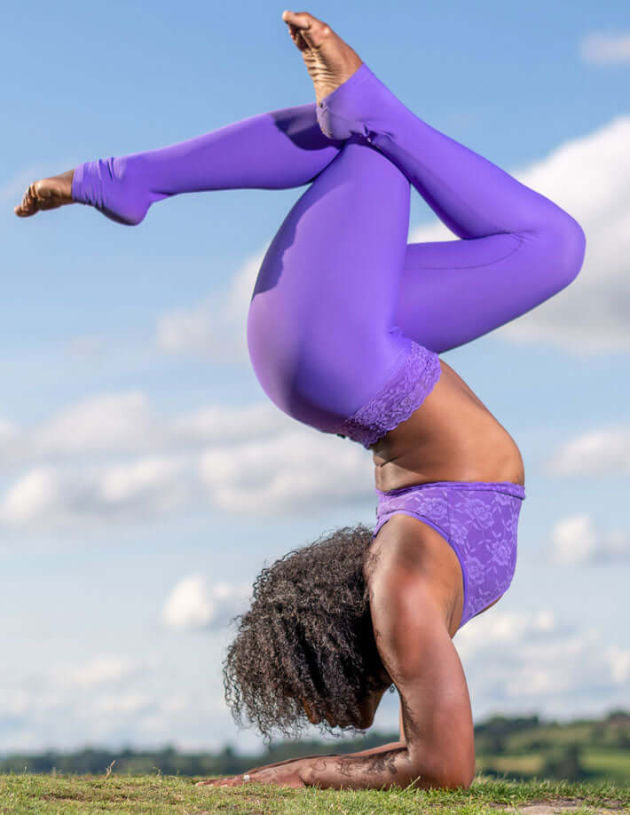 Lila spetsleggings med hög midja och matchande sport-bh i stretchigt material, utomhusmiljö.