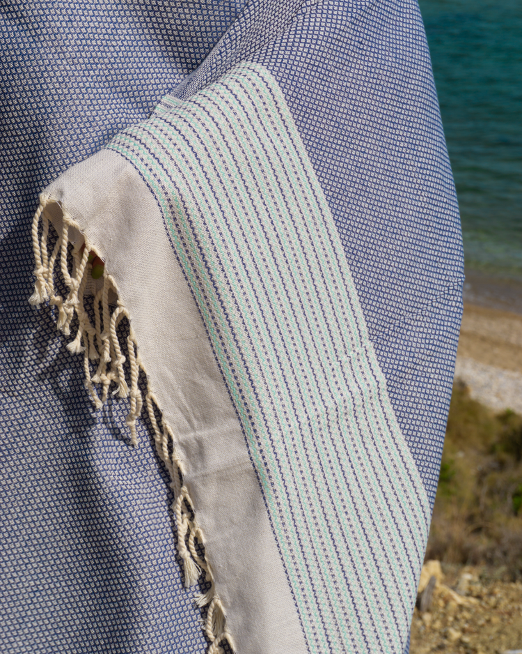 Mörkblå turkisk hammam handduk med fint mönster och fransar i vitt och blått.