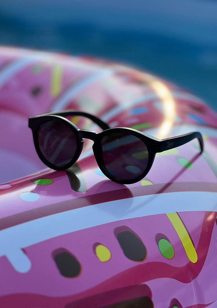 Runda svarta solglasögon i handgjort bambuträ med mörka polariserade linser.