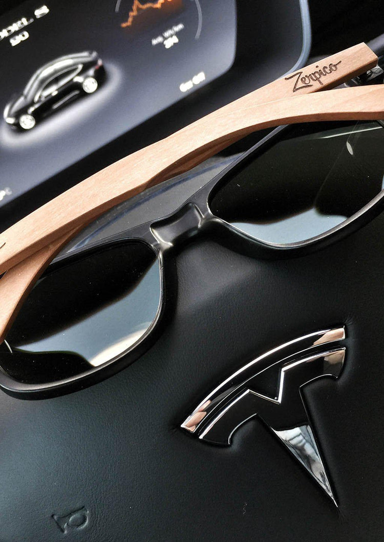 Svarta wayfarer-solglasögon med polerade svarta linser och rosenträram, handgjorda detaljer.