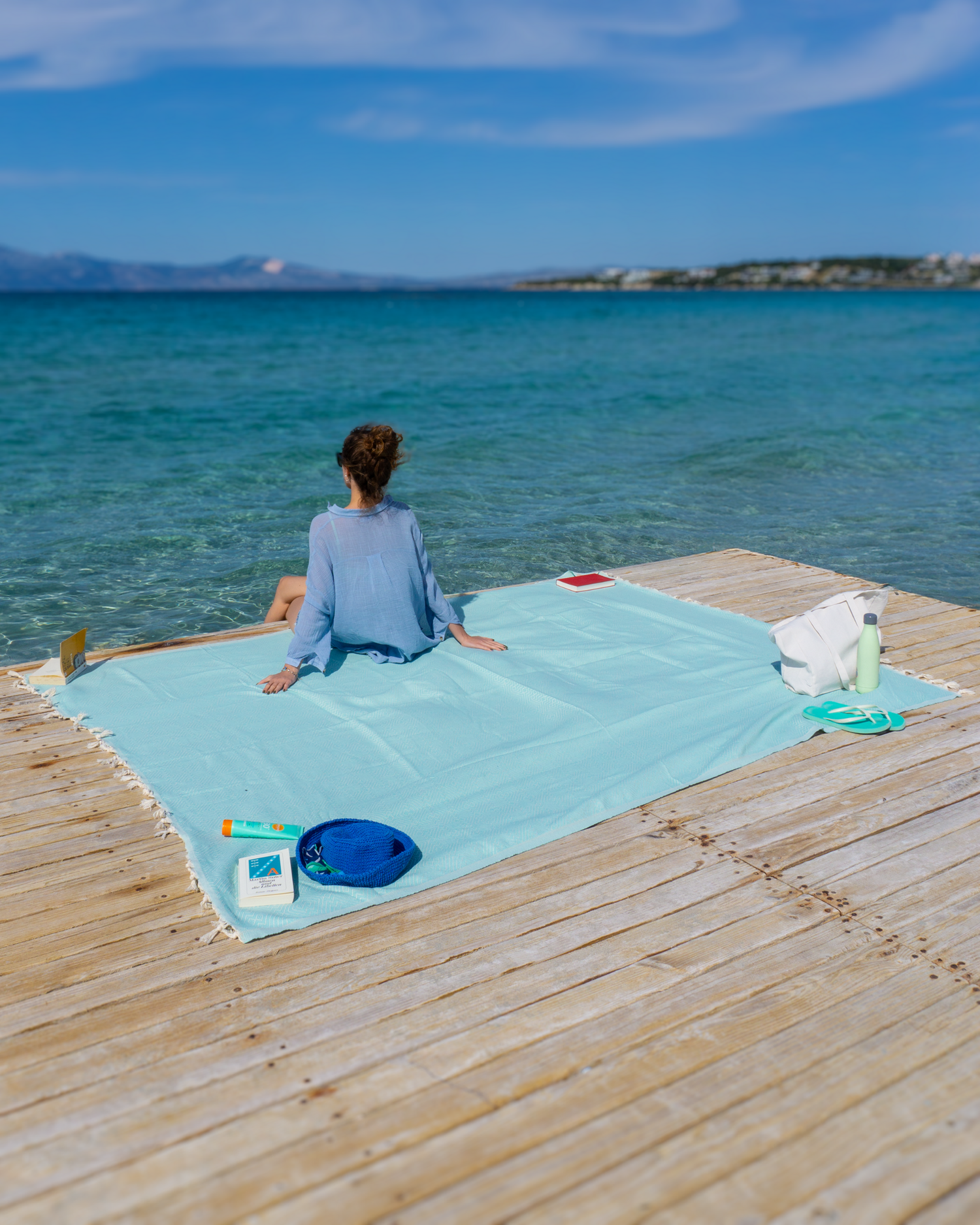 Mintgrön XXL hammamhandduk i bomull, snabbtorkande och sandresistent, bredd på träbrygga vid havet.