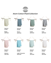 Stor mintgrön hammamhandduk i bomull med vit randig plaiddesign, upphängd på träspett.