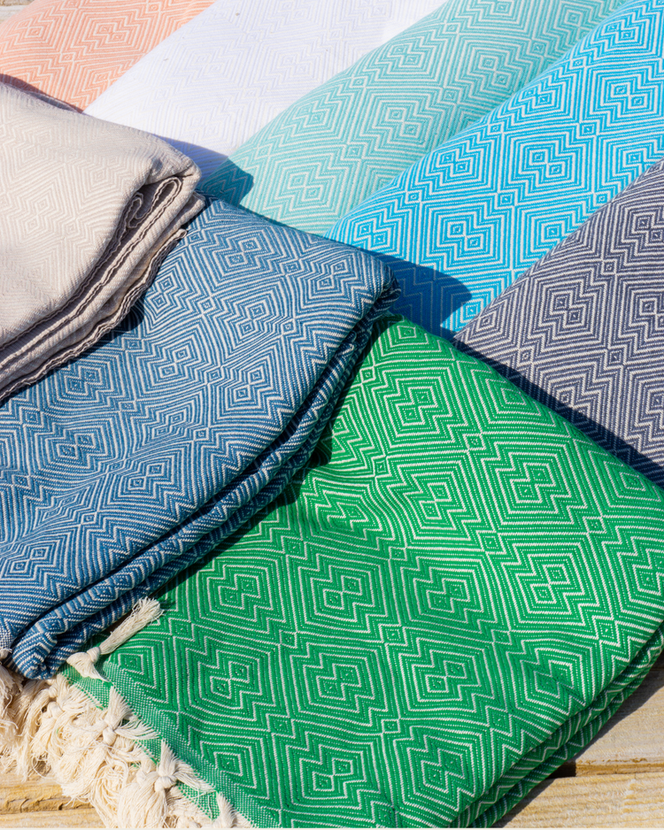 Färgglada hammamhanddukar med geometriskt mönster i grön, blå, turkos, beige och grått, med fransar i kanten.