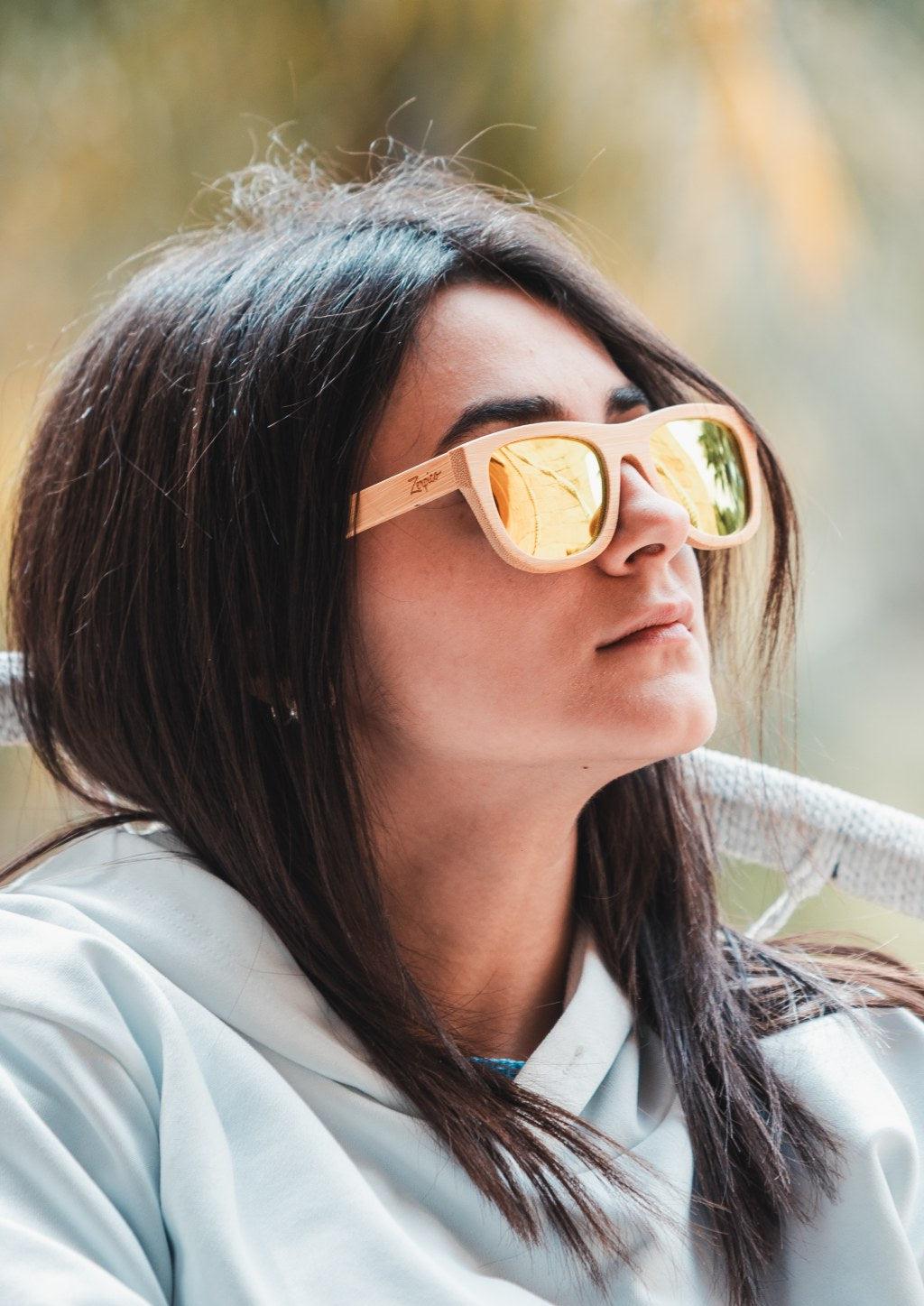 Wayfarer solglasögon i ljus naturlig bambu med polariserade spegelglas och flexibla gångjärn.