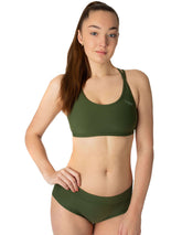 Mörkgrön sport-bh med breda axelband och diskret logga framtill, stretchigt material.