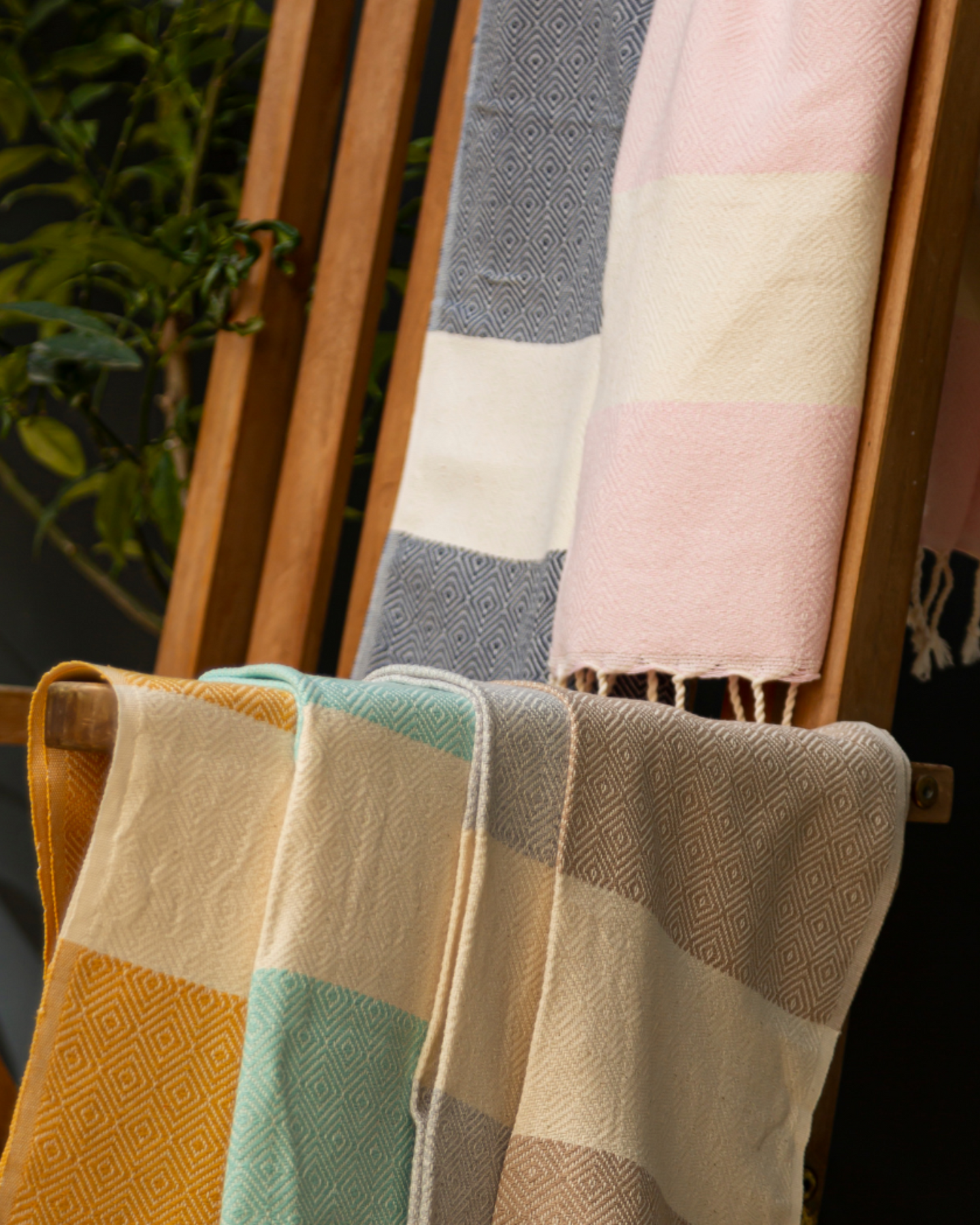 Flera mjuka bomullshanddukar i mint, beige, rosa och grå med fransar, naturlig textur.