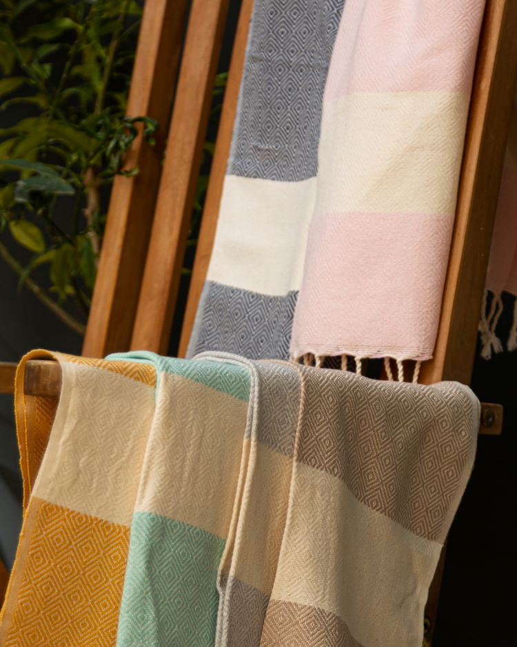 Flerfärgad hammam handduk i blått, beige och pastell, med fransar och vävd struktur.