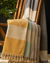 Färgglada pestemal handdukar i breda ränder med tofsar i gula, gröna och rosa toner.