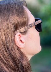 Solglasögon med mörk polariserad lins och handgjord rosenträplastram med vikingrunor, profilvy.