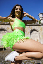 Limegröna shorts med fransar, elastisk midja och justerbar dragsko, sportig stil.