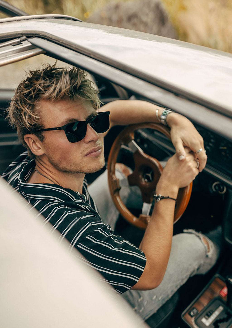 Svarta vikbara Wayfarer-solglasögon med gråa linser och tunn ram i lättviktsdesign.