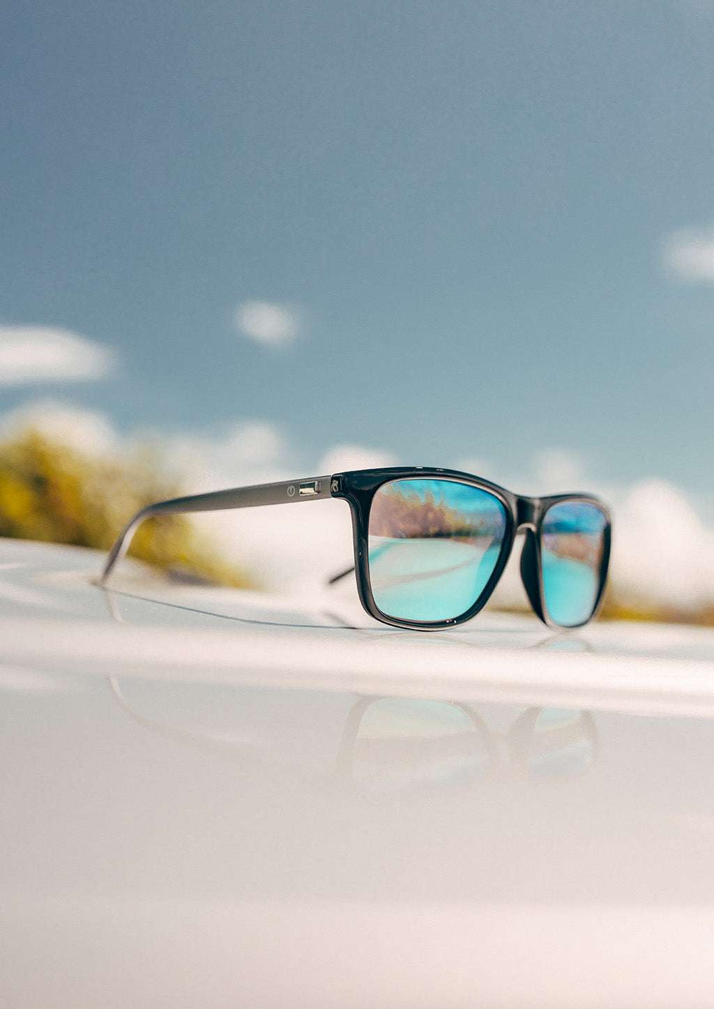 Svarta Wayfarer-solglasögon med blåtonade spegelglas och aluminiumskalmar.