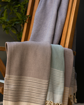 Ljusblå och mintfärgad turkisk hammam handduk i bomull med dekorativa ränder och fransar.