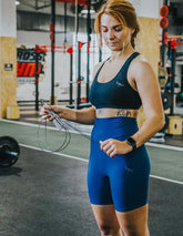 Svart racerback träningsbh med breda axelband och elastisk nederkant, sportig design.