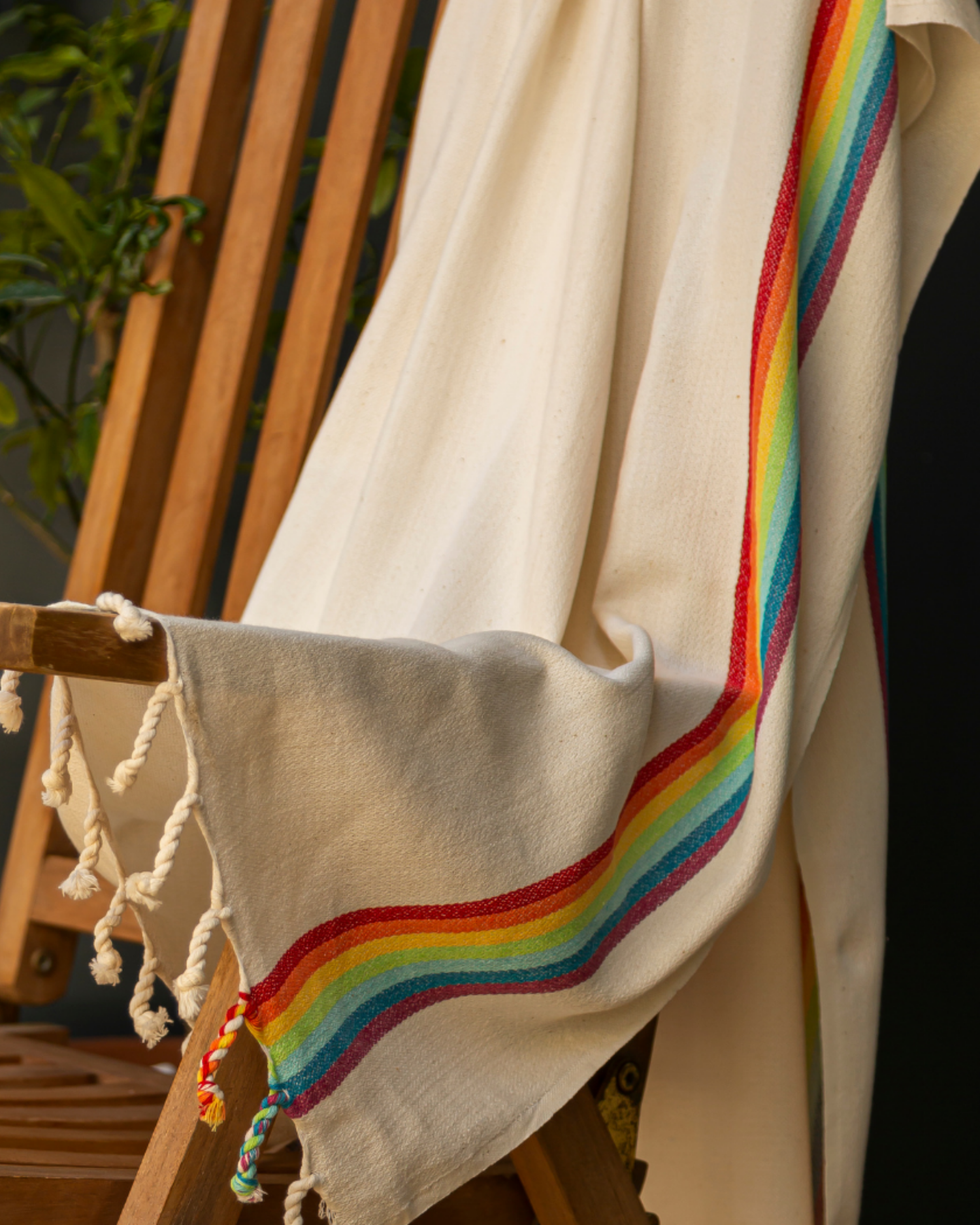 Beige bomullsstrandhandduk med regnbågsrand och tofsar, turkisk hammamstil.