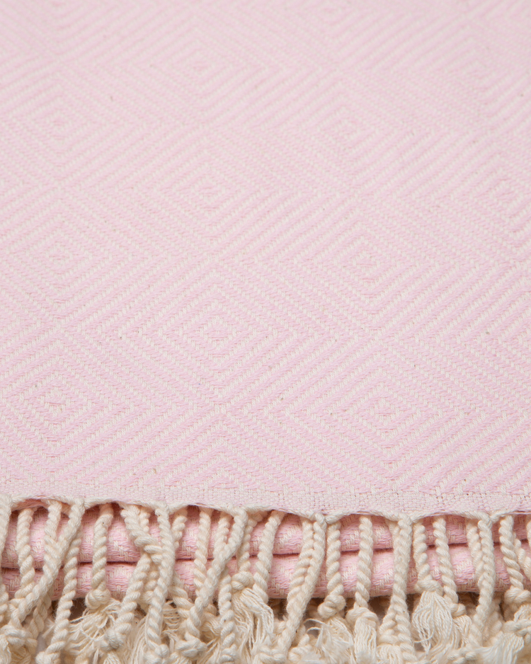 Ljusrosa turkisk bomullsstrandhandduk med geometriskt mönster och fransar.
