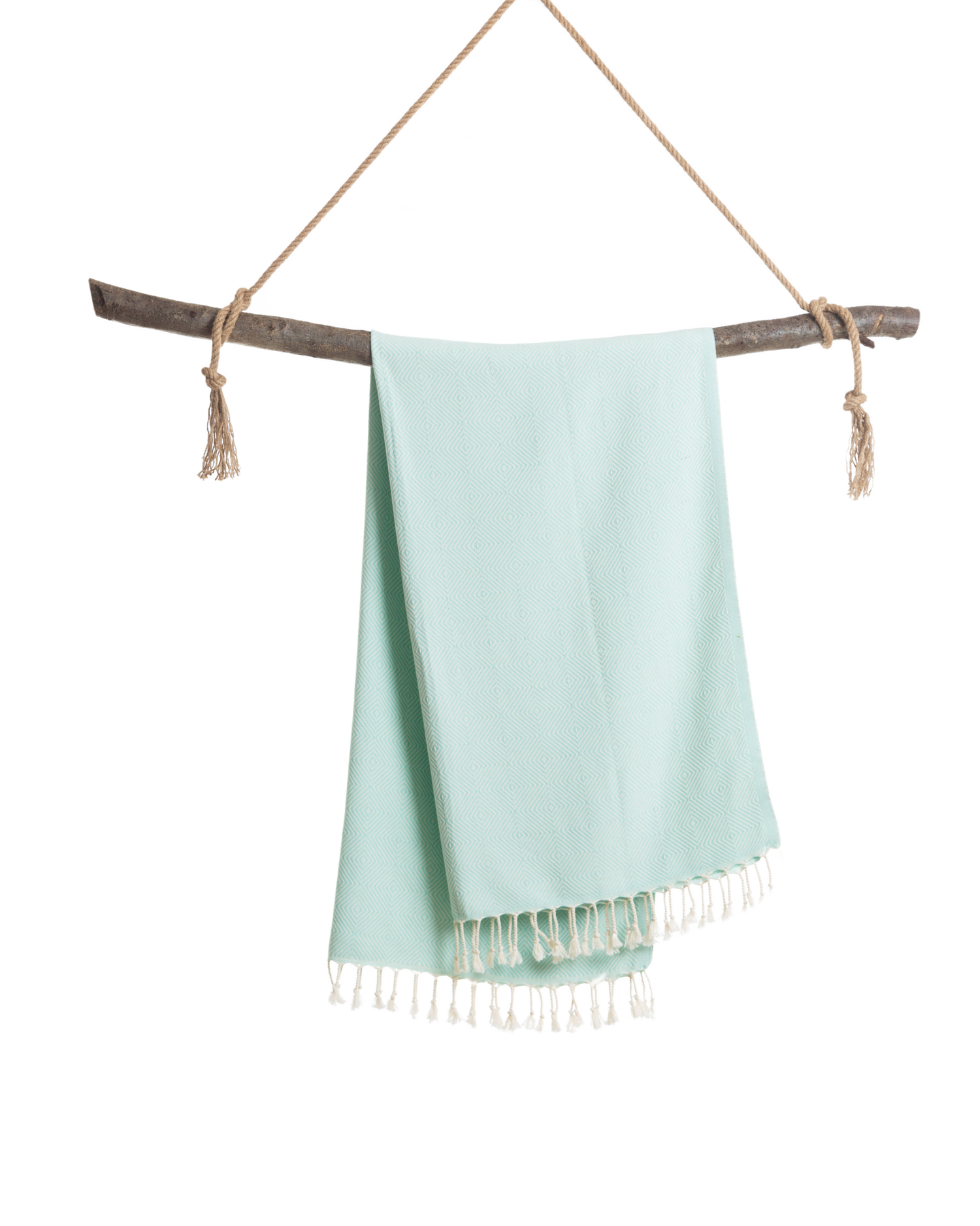 Mintgrön turkisk hammam handduk i bomull med fransar, hängande över träpinne.