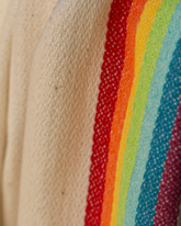 Regnbågsfärgad bomulls- och bambustrandponcho med huva och våffelvävt mönster.