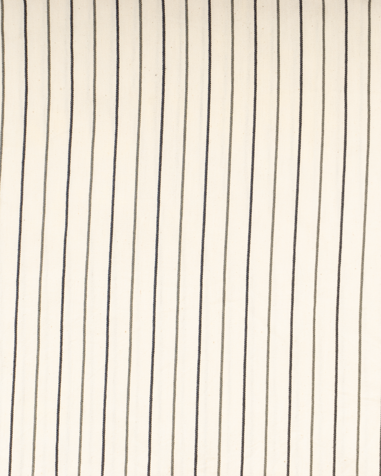 Vit strandponcho med svart smalrandig design i lätt bomullsmaterial.