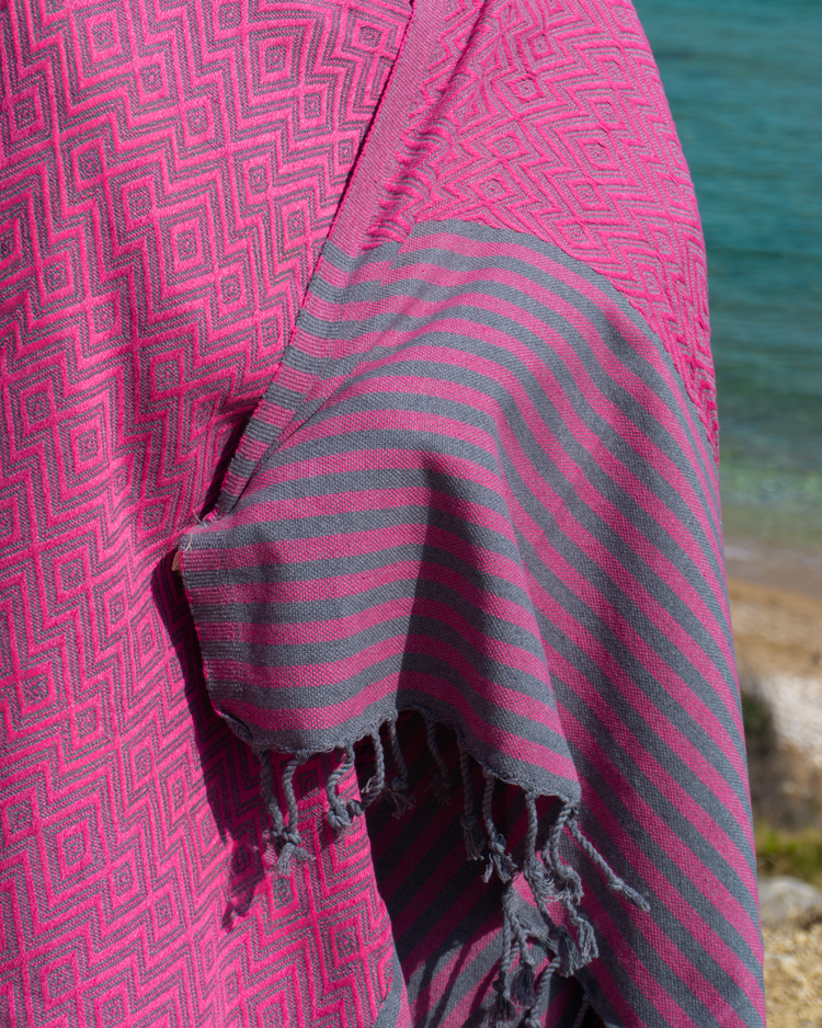 Körsbärsröd och grå hammam strandhandduk med geometriskt mönster och fransar, lättviktsmaterial.