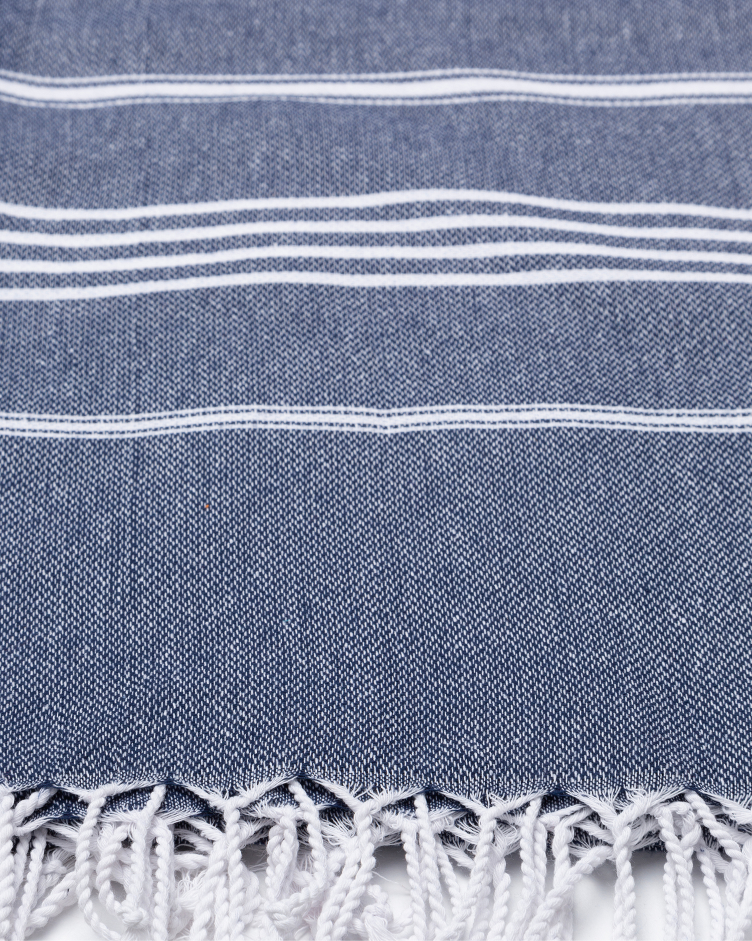 Mörkblå bomullshammamhandduk med vita ränder och fransar i nederkant.