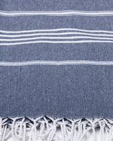 Mörkblå bomullshammamhandduk med vita ränder och fransar i nederkant.