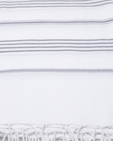 Vit bomullshandduk med grå ränder och fransar i traditionell hammamstil.