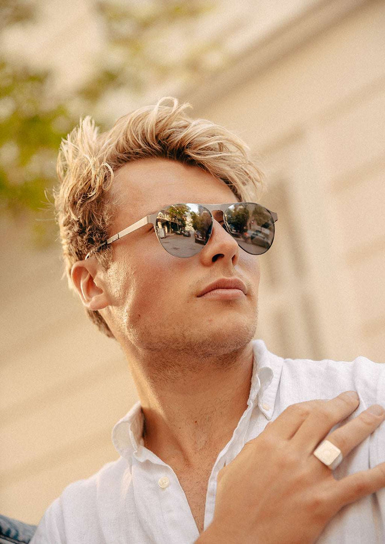 Svarta vikbara aviatorsolglasögon med metalldetaljer och polariserade spegelglasögon.