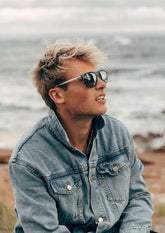 Solglasögon i modern wayfarerstil med svart plastfront och silverfärgade aluminiumskalmar.