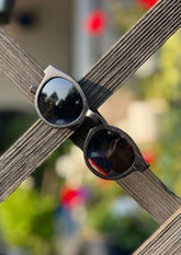 Runda solglasögon med svarta bambubågar och polariserade mörka glas.