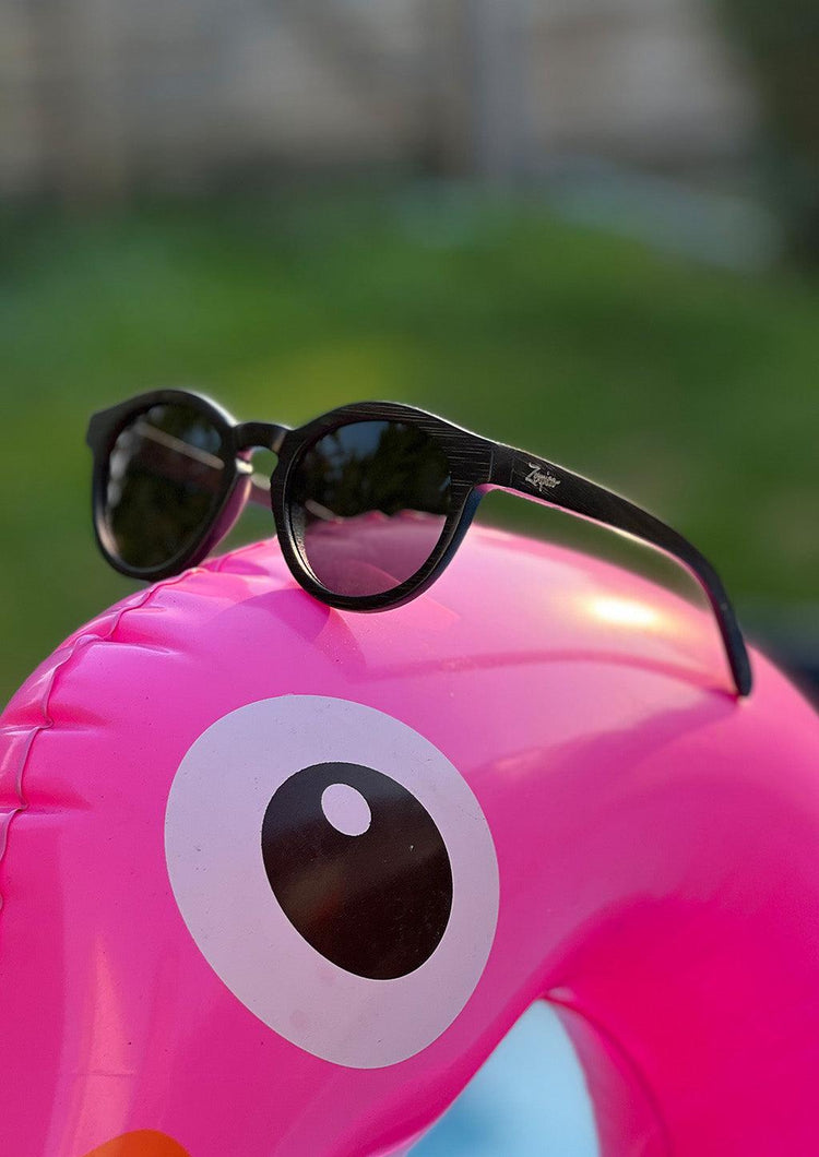 Runda svarta bambusolglasögon med polariserade mörka linser och diskret Eyewood-logotyp.