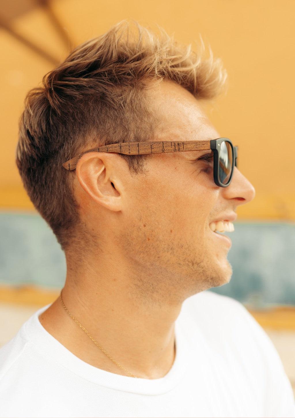 Handgjorda wayfarer-solglasögon i valnötsträ med svart polariserad lins och gravyrdetaljer.