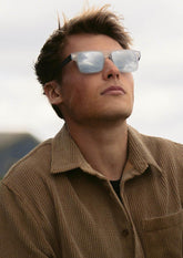 Svarta fyrkantiga solglasögon i kolfiber och acetat med blå spegelglas.