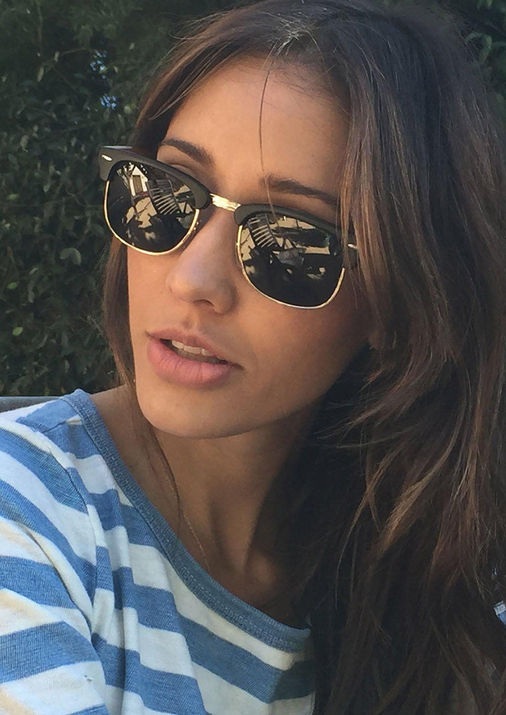 Svarta solglasögon med spegellinser och en klassisk clubmaster-ram i trä och plast.