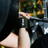 Armégrönt handledsstöd i neopren med svart kardborrespänne, används vid styrketräning.