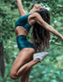Emeraldgrön sammetsshorts med hög midja och sportig passform, parat med matchande sport-bh i sammet.