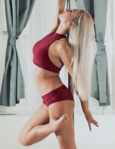 Burgundy halterneck sport-bh med vadderade kupor och sömlös design, kroppsnära passform.