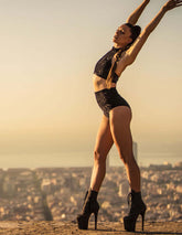 Svart sammetscrop top med elegant halsbanddetalj, figurnära och stilren design.