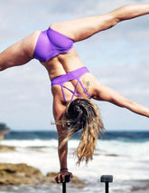 Violett sport-BH med korslagda band och ventilationspaneler, sportig och stödjande design.