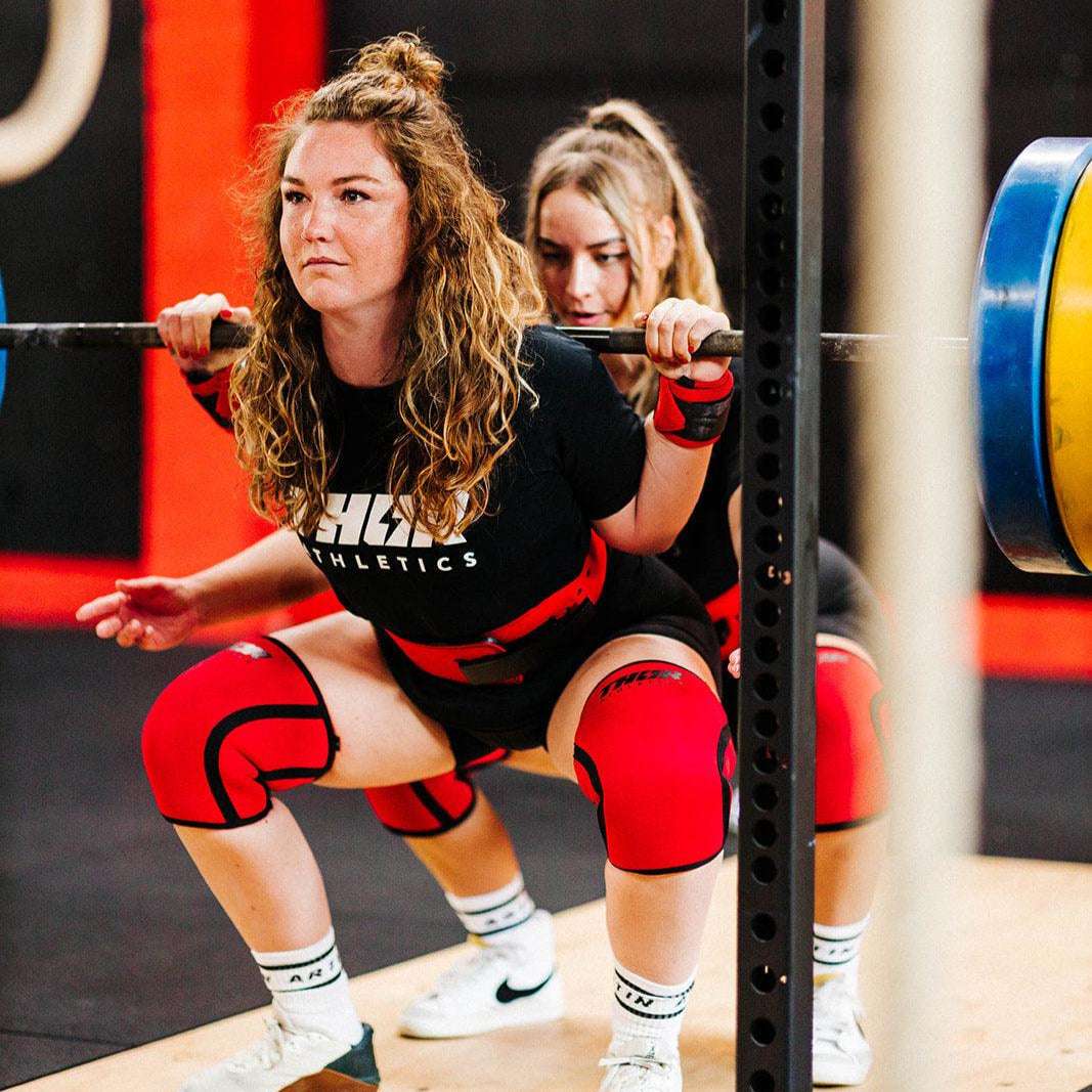 Röda 7mm knäskydd i neopren med svart söm, slitstark för träningsstöd och kompression.