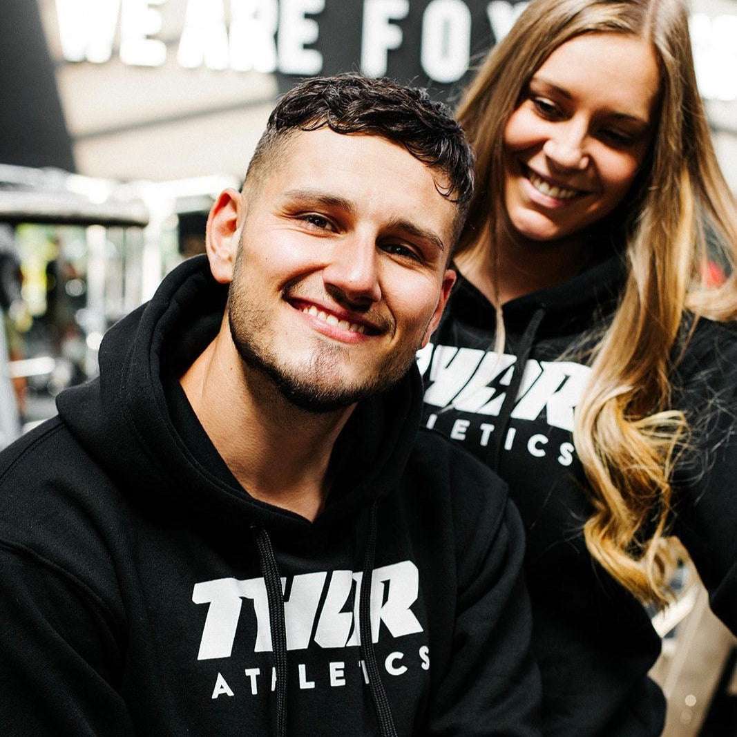 Svart hoodie med vit tryckt text, rymlig huva och känguruficka i mjukt tyg.