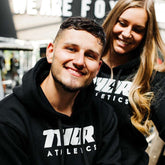 Svart hoodie med vit tryckt text, rymlig huva och känguruficka i mjukt tyg.